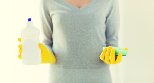 Professional cleaner tidying a kitchen in Dulwich